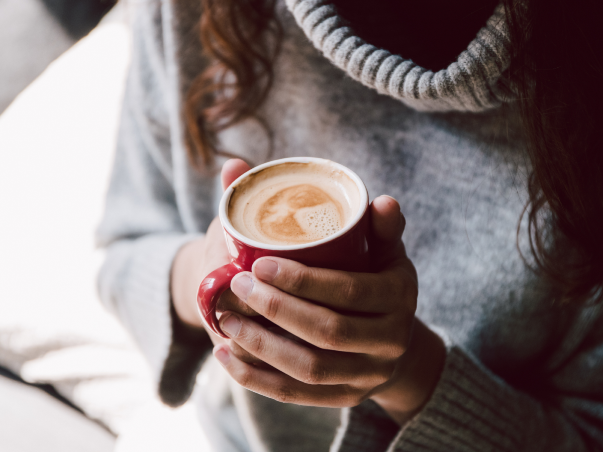 Woman In Sweater Holding Warm Mug Of Golden Cocoa Coffee