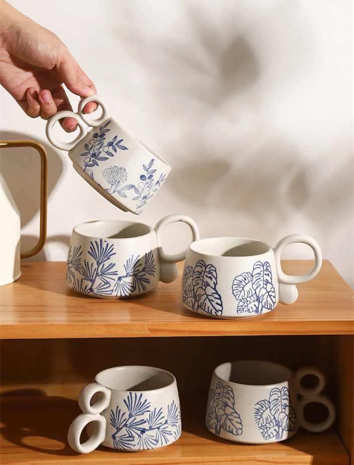 Picking Up A Two Loop Handled Mug With Garden Floral Pattern Nature In Blue Ceramic Cups with Plant Designs And Unique Handle Shapes