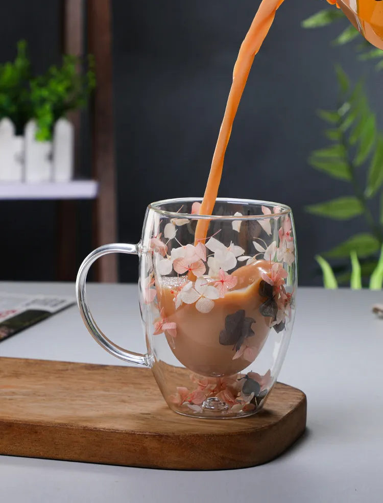 Pouring Cold Brew Coffee Beverage Into Glass Mug Filled With Flowers Pink And Black Hydrangea Petals