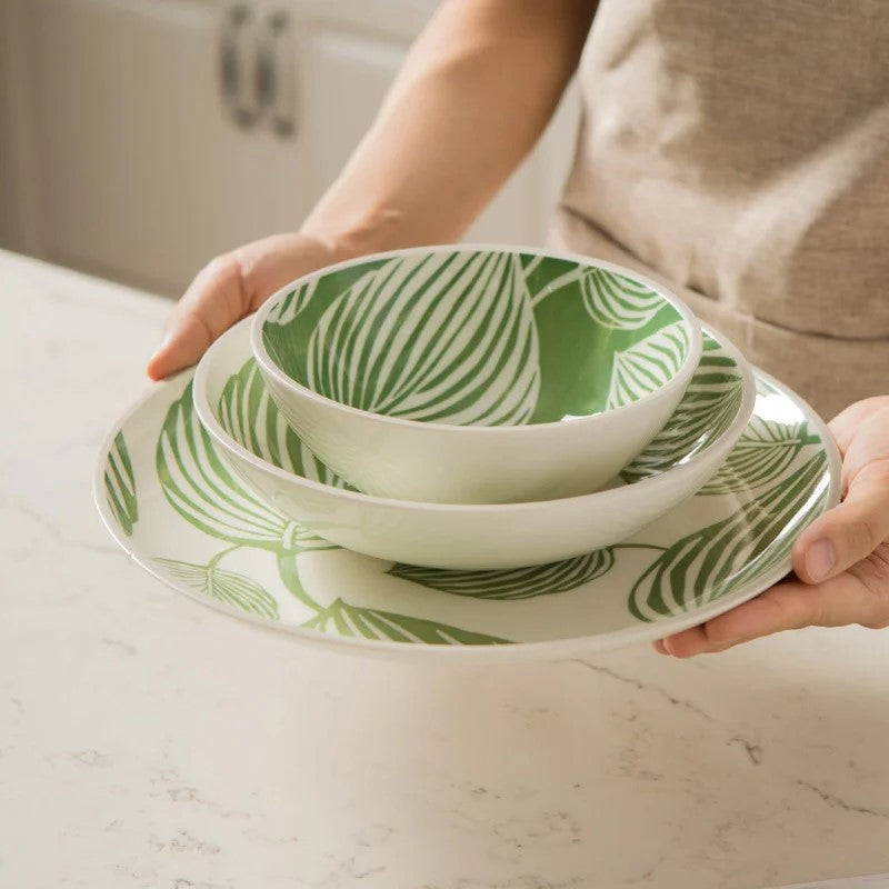 Holding Place Setting Dishes With Tropical Leaf Patterns Ceramic Bowls And Plate In Leafy Green Pattern