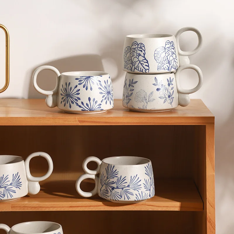 Nature In Blue Ceramic Mugs With Loop Handles On Wooden Shelves