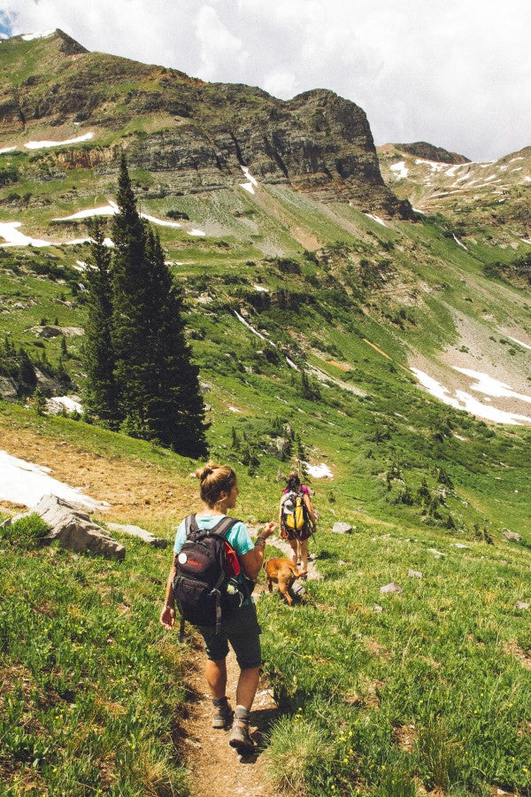 People Hiking Outdoors In The Mountains Carrying Healthy Snacks In Backpacks