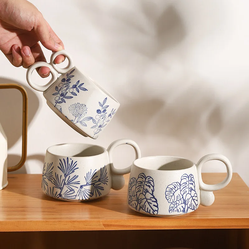 Picking Up A Double Loop Handle Mug With Blue Floral Nature Pattern Ceramics