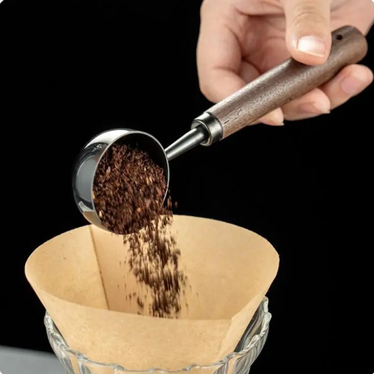 Pouring Coffee Grounds Into Unbleached Coffee Filter For Coffee At Home Using Luxury Barista Wood And Stainless Steel Scoop