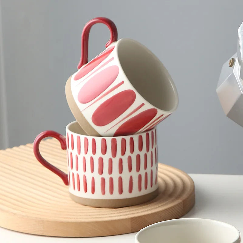 Grounded Art Pottery Collection Stacked Mugs With Dark Handles Ceramic Cups With Red And White Patterns And Exposed Bases