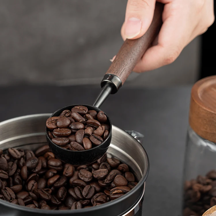 Scooping Coffee Beans To Brew Coffee At Home In Luxury Barista Style Using Dark Stainless Steel And Wood Coffee Scoop Spoon