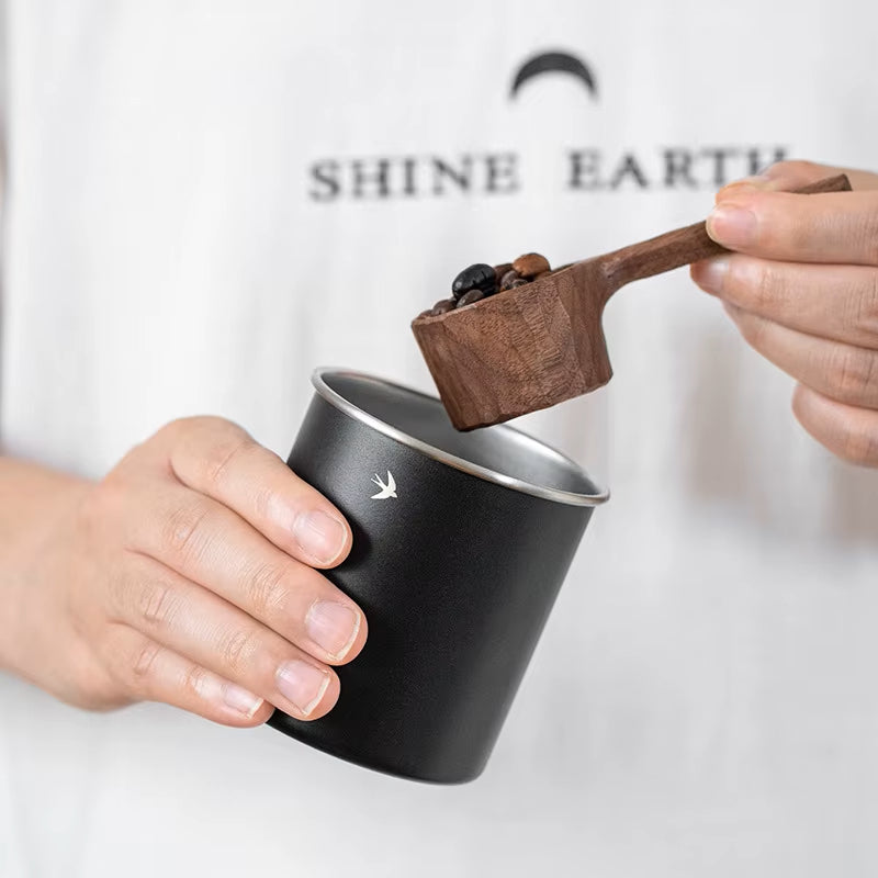 Scooping Coffee Beans From Metal Coffee Canister