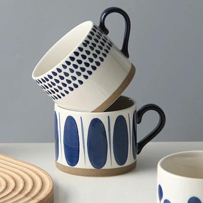 Grounded Art Pottery Collection Stacked Mugs With Dark Handles Ceramic Cups With Blue And White Patterns And Exposed Bases