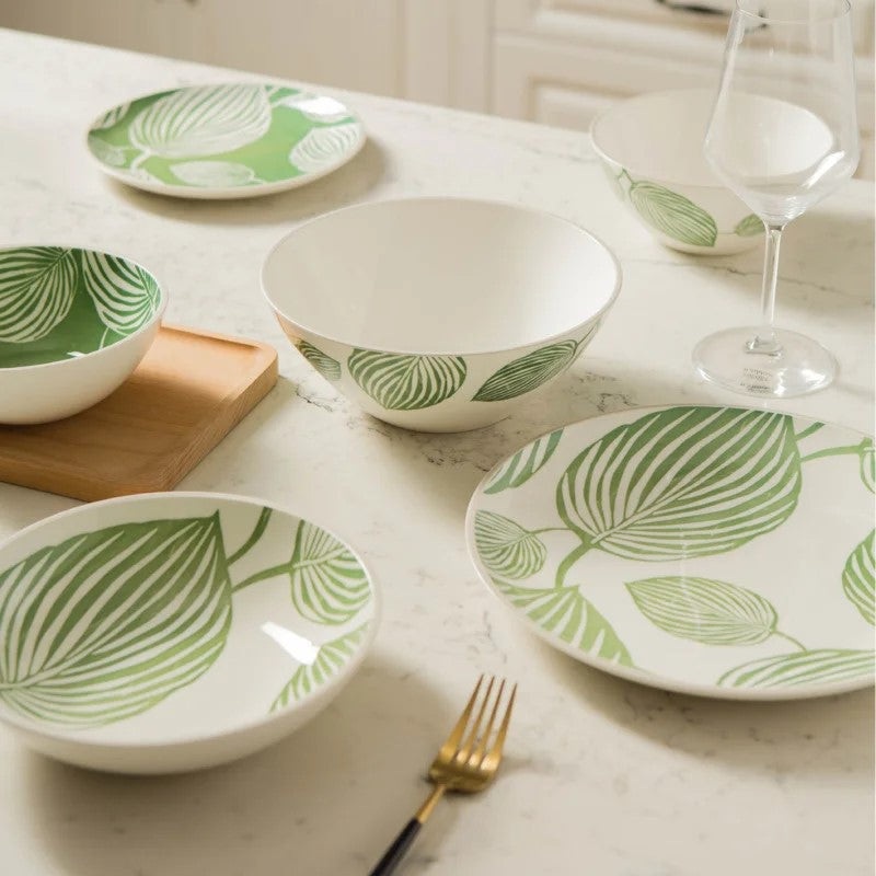 Table Set With Ceramic Leafy Green Dinnerware Plates And Bowls With Tropical Leaf Patterns
