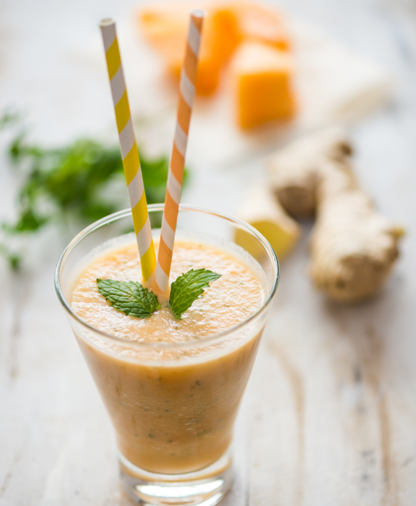 Yellow And Orange Paper Straws In Healthy Coconut Water Smoothie With Ginger Root And Mint Leaves