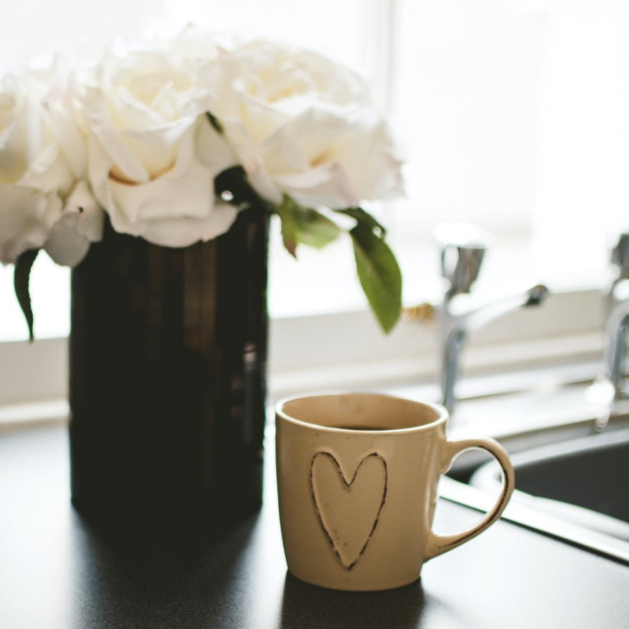 Beige Mug With Heart Full Of Sweet Love Coffee On Kitchen Counter With Flowers