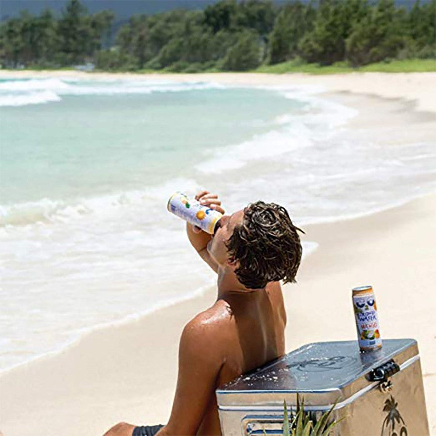 Man Drinking Mango C2O Coconut Water At The Beach