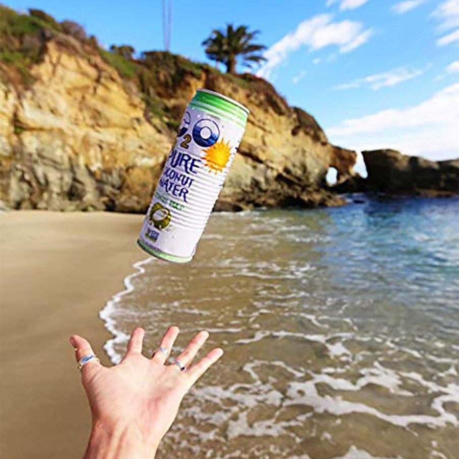 Hand With Wave Tattoo On Wrist Tossing A C2O Can Up In The Air To Catch While At The Beach Styaing Hydrated With Coconut Water With Pulp