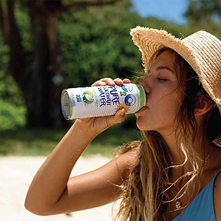 Woman In Summer Hat Outdoors Drinking C2O Pure Coconut Water With Coconut Pulp