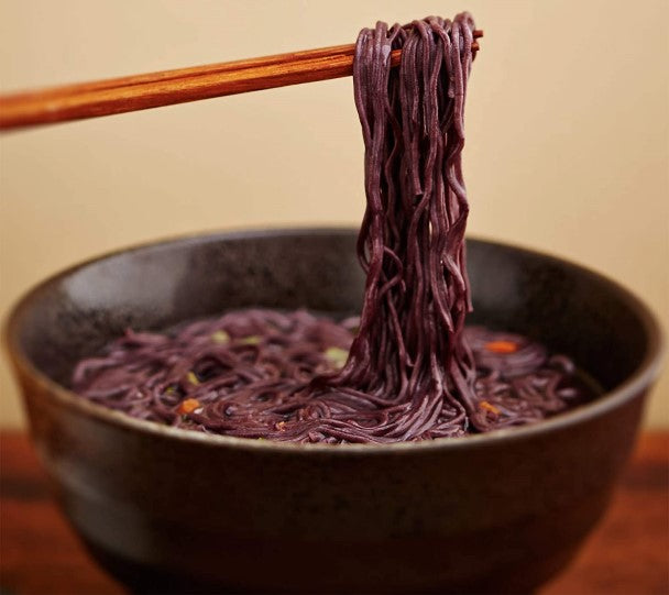 Using Chopsticks To Enjoy Bowl Of Healthy Purple Ramen Soup Made With Organic Lotus Foods Forbidden Rice Ramen Noodles
