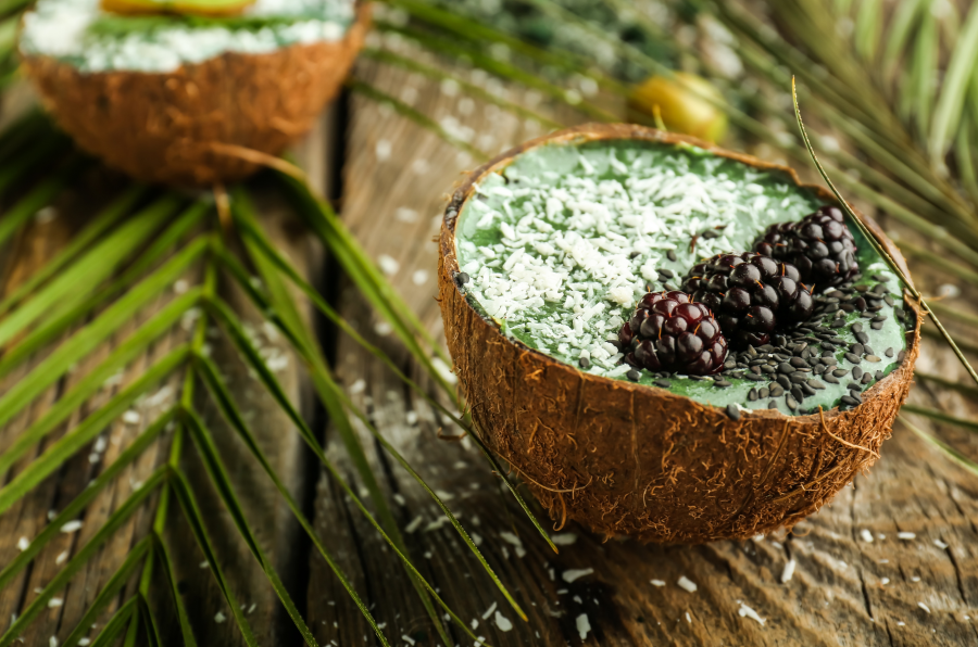 Tropical Coconut Bowl Full Of Healthy Green Smoothie Made With Coconut Water With Pulp Topped With Shredded Coconut Blackberries And Seeds