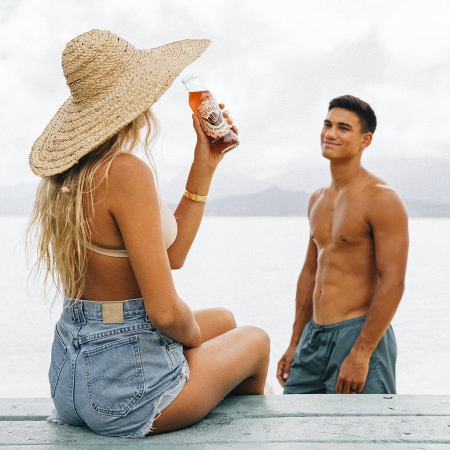 Couple At The Beach In Hawaii Drinking Shaka Guava Gingerblossom Bottled Tea