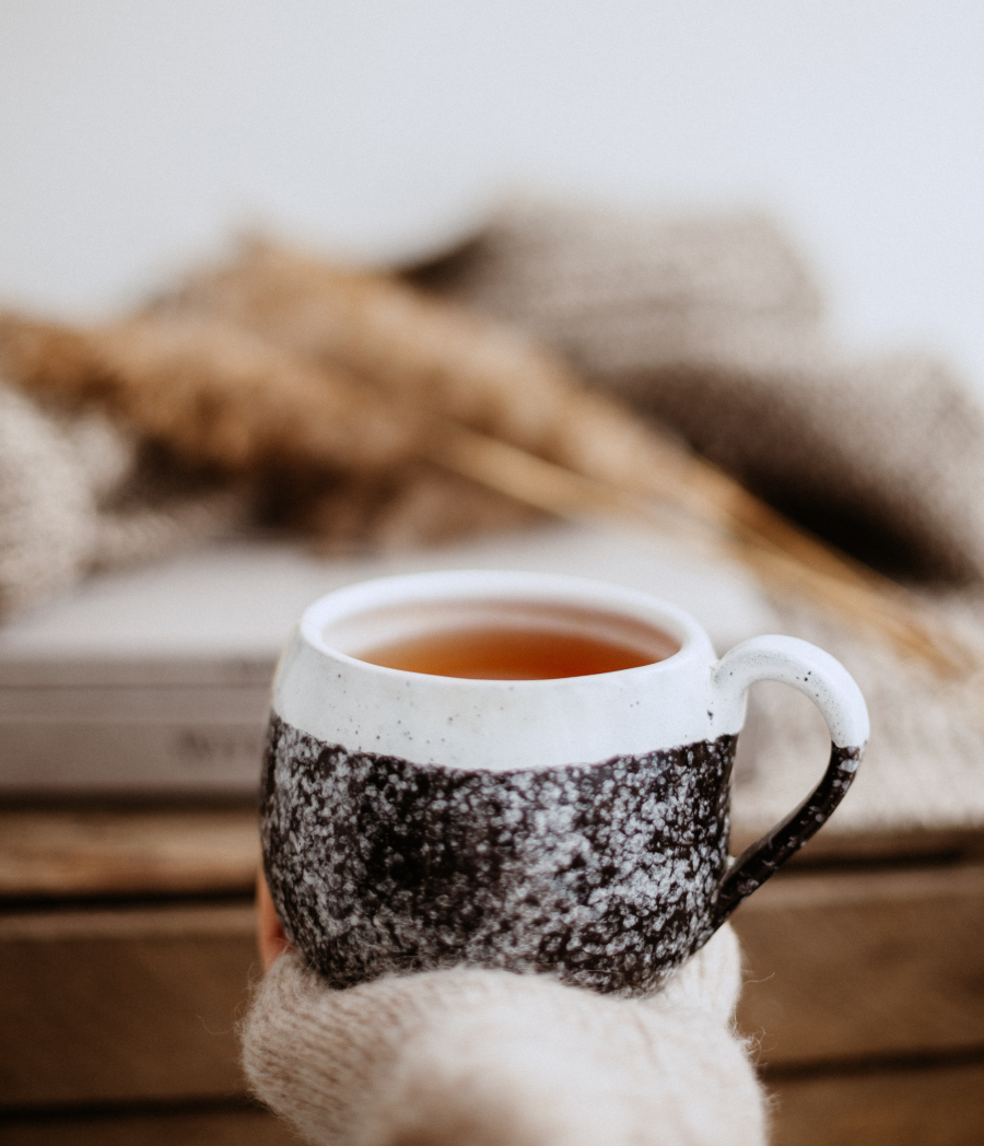 Hand Holding A Mug Of Hot Herbal Tea Outdoors