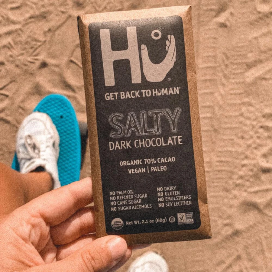 Hand Holding Hu Get Back To Human Salty Dark Chocolate Bar On Beach
