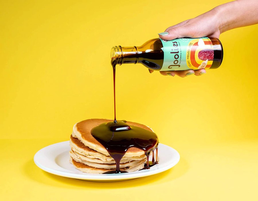 Pouring Joolies Date Syrup On Pancakes For Low Glycemic Healthy Syrup Choice