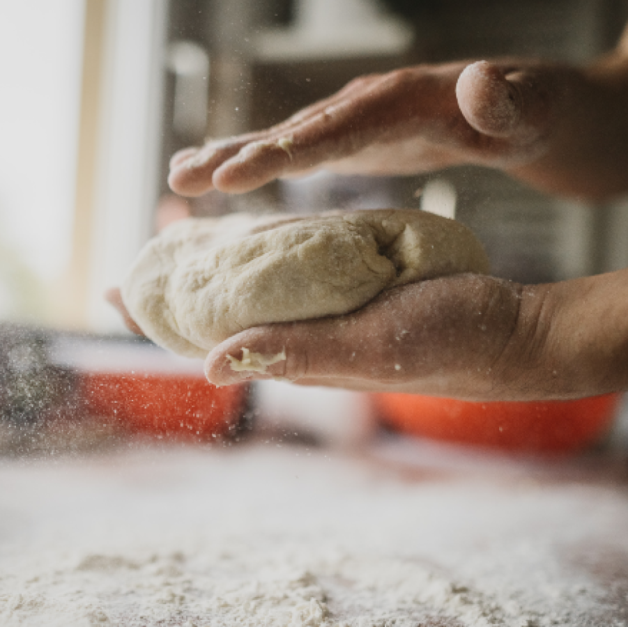Hands working the fresh dough from The Essential Baking Company for the Rosemary Bread to take and bake.