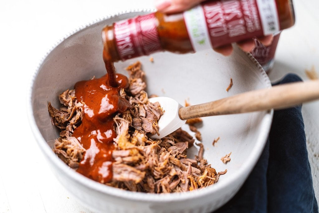 Pouring Classic Barbeque Sauce In Bowl For Primal Kitchen Recipe Keto Slow Cooker Pulled Pork With BBQ Sauce