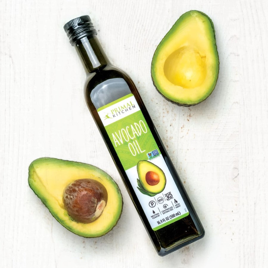 Glass Bottle Of Primal Kitchen Avocado Oil With Fresh Avocados