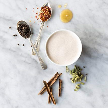 A chai tea latte made with Rishi Masala Chai concentrate and garnished with herbs for a perfect taste.