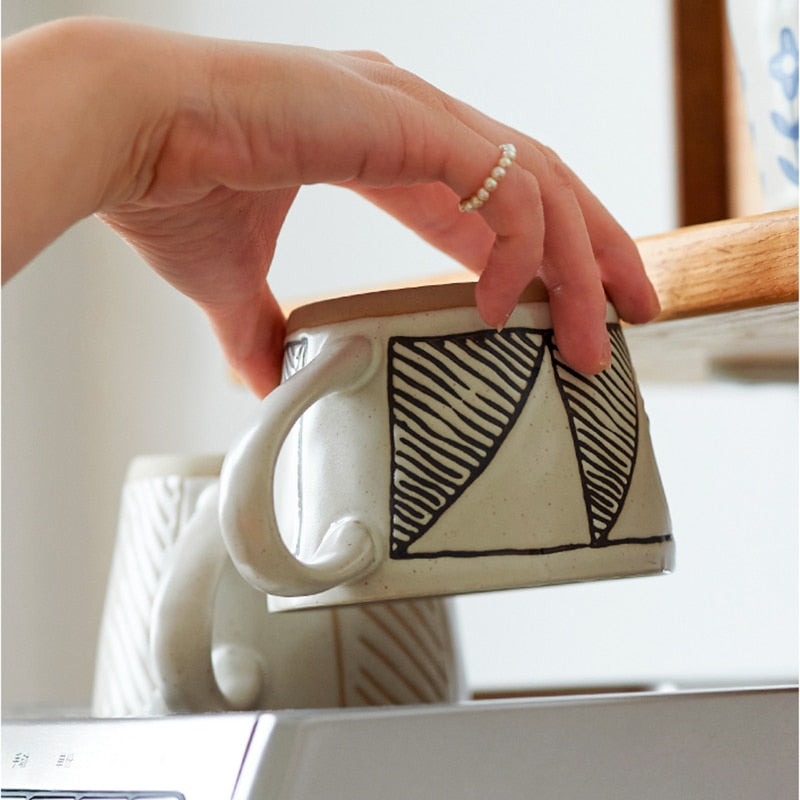 Woman's Hand Holding Diagonal Pattern Craft Style Ceramic Mug With Exposed Base