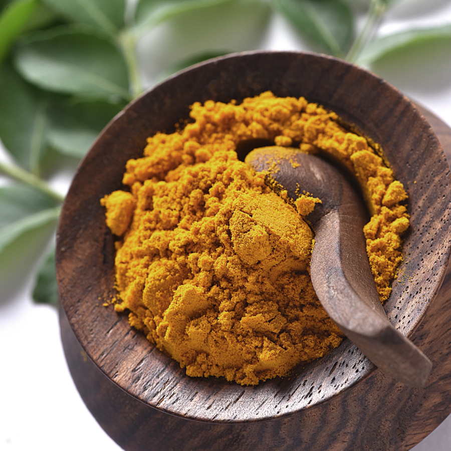 Organic Turmeric Root Powder In Wooden Bowl