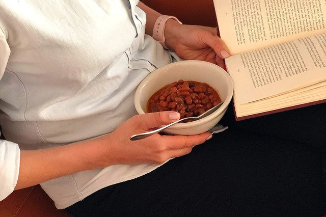 Woman Eating Bowl Of Fillo's Pinto Beans Tex-Mex Sofrito