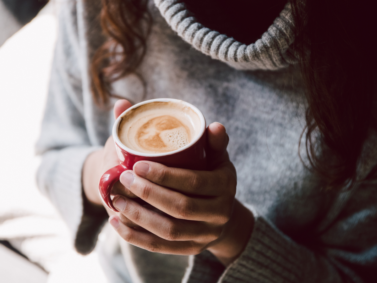 Woman In Grey Sweater Holding Red Mug Of Real Hazelnut Coffee Jim's Organic