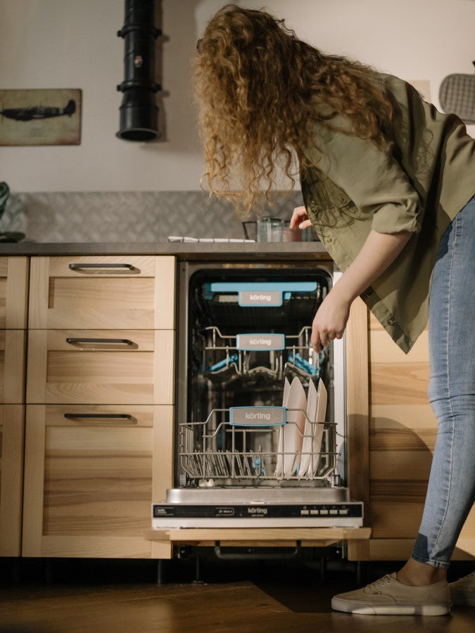 Woman Loading Dishwasher If You Care Sponge Cloths Are Dishwasher Safe