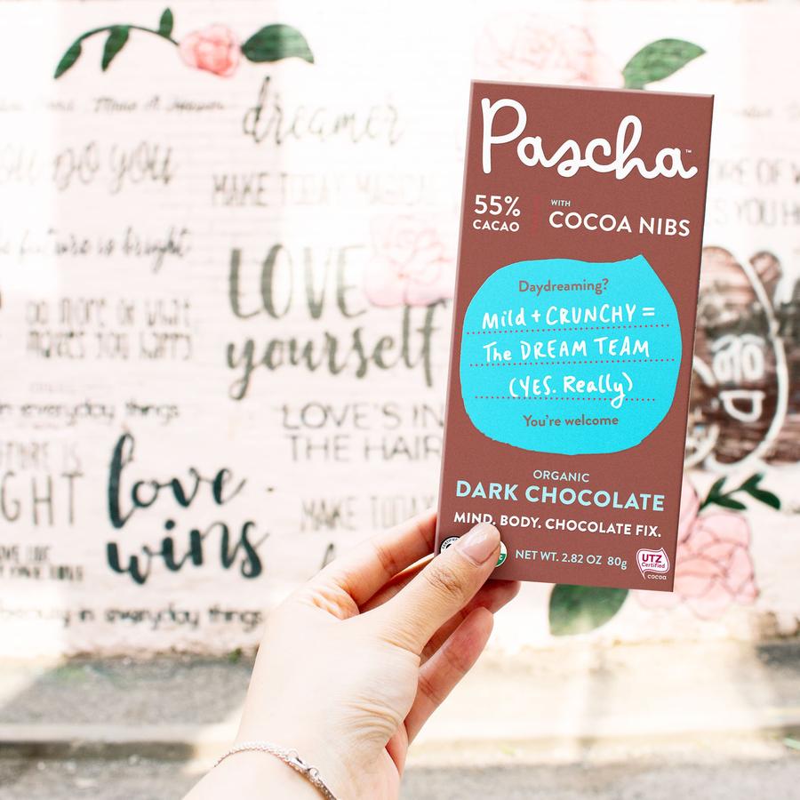 Hand Holding Pascha 55% Cacao Bar With Cocoa Nibs Mild Plus Crunchy Dream Team Organic Dark Chocolate